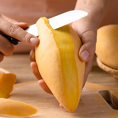 Peeling a mango with a knife