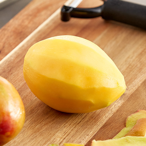 Peeled mango on a cutting board